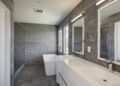 large transitional master gray tile and cement tile porcelain tile and gray floor bathroom design in San Francisco with flat-panel cabinets, white cabinets, gray walls, an integrated sink, quartz countertops and a hinged shower door