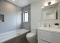 Mid-sized transitional 3/4 gray tile and porcelain tile bathroom photo in San Francisco with flat-panel cabinets, white cabinets, an integrated sink, a one-piece toilet and white walls